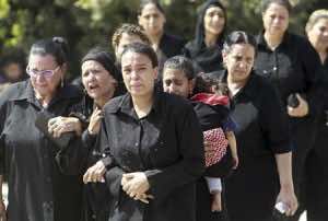 Egyptian Christian women grieve before a mass funeral for victims of sectarian clashes with soldiers and riot police at a protest against an attack on a church in southern Egypt at Abassaiya Cathedral in Cairo