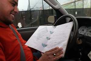 Sulaymaan Cherif looks at the guest book he keeps in his cab. Cherif says he enjoys dispensing advice.